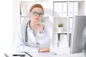 Young brunette female doctor at work in hospital. Physician ready to help. Medicine and healthcare concept