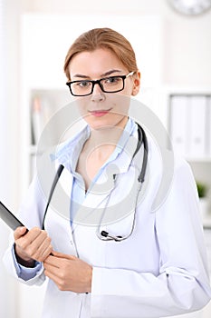 Young brunette female doctor at work in hospital. Physician ready to help. Medicine and healthcare concept