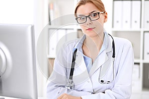 Young brunette female doctor at work in hospital. Physician ready to help. Medicine and healthcare concept