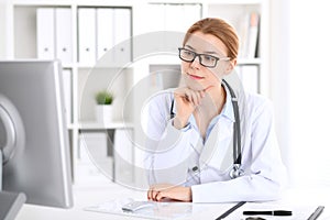 Young brunette female doctor at work in hospital. Physician ready to help. Medicine and healthcare concept