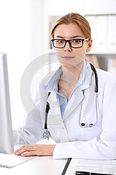 Young brunette female doctor at work in hospital. Physician ready to help. Medicine and healthcare concept