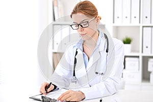 Young brunette female doctor at work in hospital. Physician ready to help. Medicine and healthcare concept