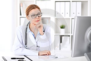 Young brunette female doctor at work in hospital. Physician ready to help. Medicine and healthcare concept photo