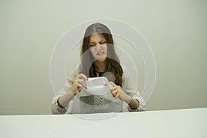 young brunette girl with her hair sits at a table with papers