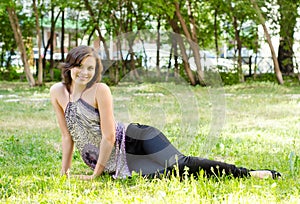Young brunette girl lying in grass