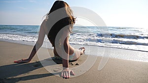 Young brunette girl in sunglasses lying on tropical beach and enjoying vacation. Attractive slim woman relaxing on coast