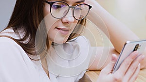 Young brunette girl uses a smartphone to communicate. Online communication in messengers,