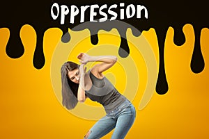 Young brunette girl wearing casual jeans and t-shirt protecting herself with hands from black OPPRESSION sign on yellow