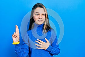 Young brunette girl wearing turtleneck sweater smiling swearing with hand on chest and fingers up, making a loyalty promise oath