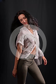 A young brunette girl in a white shirt is dancing