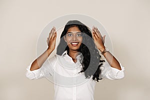 Young brunette indian woman smiling and expressing surprise