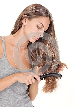 Young brunette lady combing long hairs