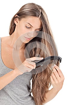 Young brunette lady combing long hairs