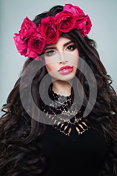 Young brunette model woman with long perfect hair and roses flowers portrait