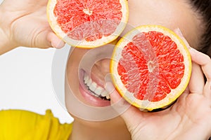 Young brunette with red grapefruit in her hand