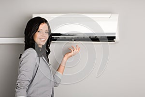 Young brunette showing the air conditioner