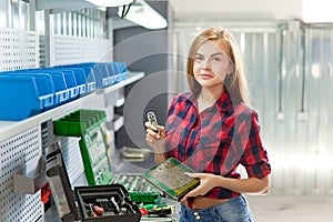 Young brunette white woman with electronic plate in a garage.