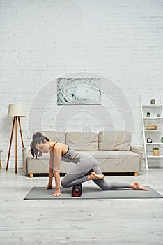 Young brunette woman in activewear massaging