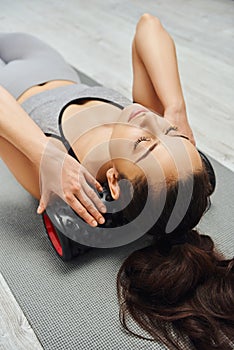 Young brunette woman in activewear massaging