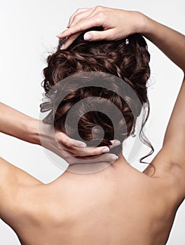 Young brunette woman from back side with knot of braided hair