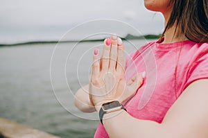 Young brunette woman with bare feet  wearing black and purple fitness outfit  stretching on violet yoga mat outside on wooden pier photo