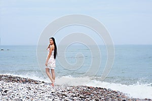 A young brunette woman on a beautiful shore