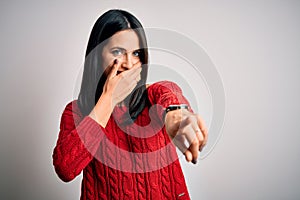 Young brunette woman with blue eyes wearing casual sweater over isolated white background laughing at you, pointing finger to the