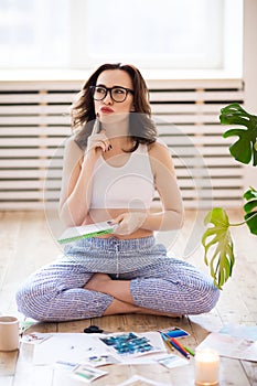 Young brunette woman creating her Feng Shui wish map using scissors