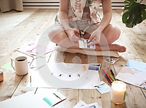 Young brunette woman creating her Feng Shui wish map using scissors