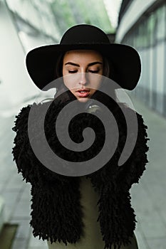 Young brunette woman in fashionable hat posing