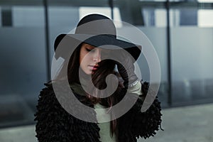 Young brunette woman in fashionable hat posing