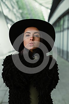 Young brunette woman in fashionable hat posing