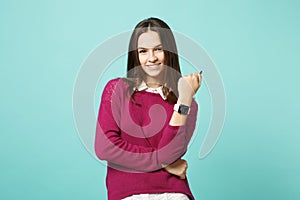 Young brunette woman girl in casual clothes posing isolated on blue green turquoise wall background studio portrait