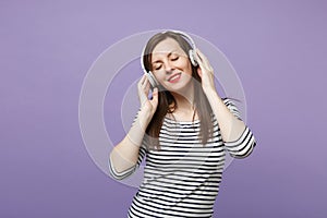 Young brunette woman girl in casual striped clothes posing isolated on violet purple background studio portrait. People