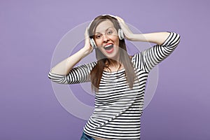 Young brunette woman girl in casual striped clothes posing isolated on violet purple background studio portrait. People