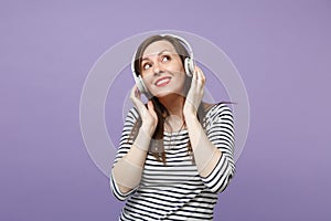 Young brunette woman girl in casual striped clothes posing isolated on violet purple background studio portrait. People