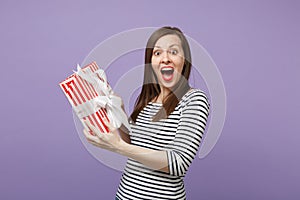 Young brunette woman girl in casual striped clothes posing isolated on violet purple background studio portrait. People