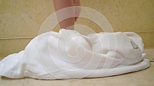 Young brunette woman going to bathroom, undressing removing bathrobe and laying in bathtube.