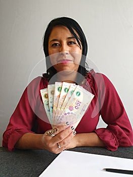 young brunette woman grabbing and showing Argentine money