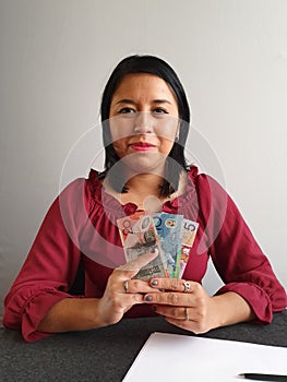 young brunette woman grabbing and showing Australian money