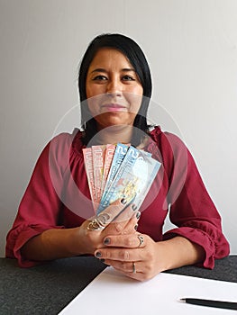 young brunette woman grabbing and showing Costa Rican money