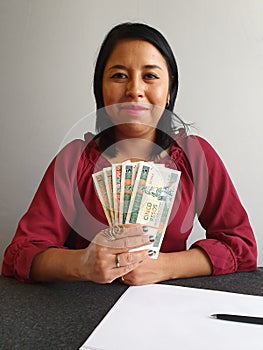 young brunette woman grabbing and showing cuban money