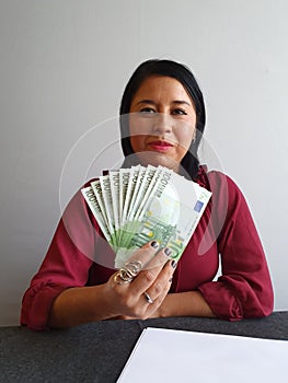 young brunette woman grabbing and showing European money