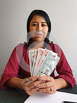 young brunette woman grabbing and showing guatemalan money