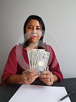 young brunette woman grabbing and showing Japanese money