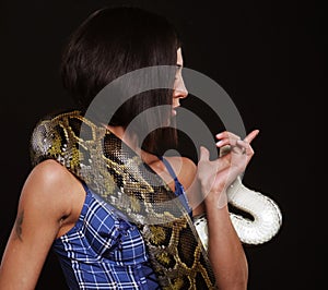 Young brunette woman holding python, big snake.