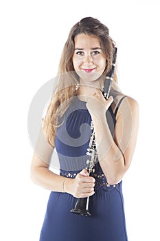 Young brunette woman holds clarinet in studio and smiles