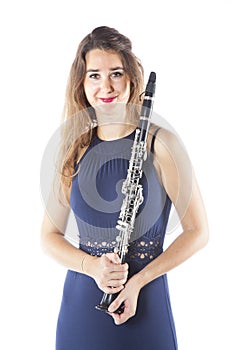 Young brunette woman holds clarinet in studio and smiles