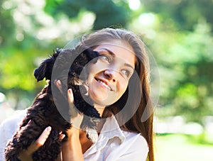 Young brunette woman hugging her lap dog puppy