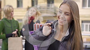 Young brunette woman with long hair smiling happily looking at camera. Happy caucasian girl with shopping bags standing